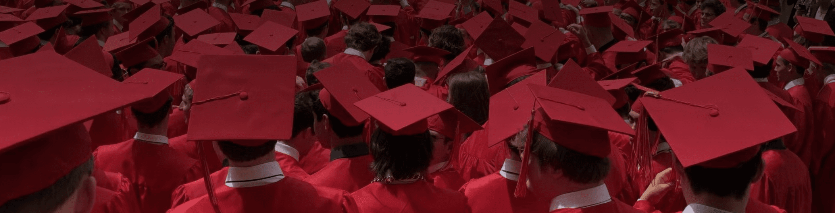 Graduating students in red caps and gowns at commencement.